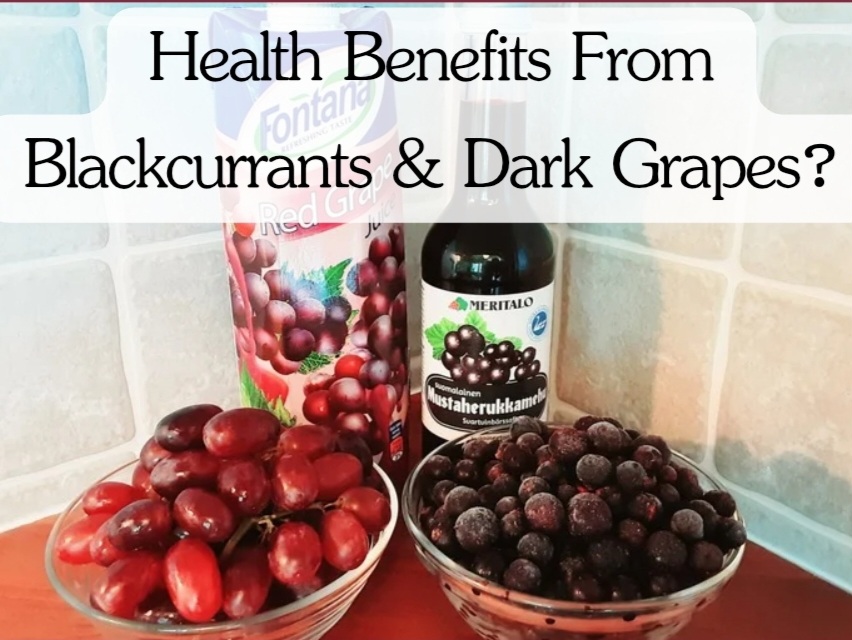Photonof fresh blackcurrants and dark grapes in two small bowls in front of two bottles with blackcurrants juice and dark grapes juice illustrating their possible healthy benefits